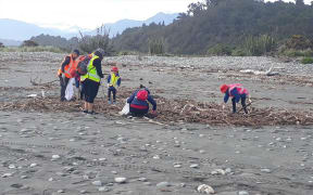 South Westland Coastal Cleanup volunteers helping clear litter and detritus swept into rivers and beaches from a disused landfill after the storm.