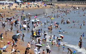People cooling off on a beach amid hot weather in Qingdao, in China's eastern Shandong province on 1 August 2022.