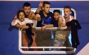 Migrants react as they wait in a train at the railway station, near the Slovenian-Croatian border in Dobova, Brezice, on September 17, 2015.