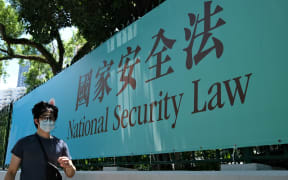 A man walks past a government public notice banner for the National Security Law in Hong Kong, 15 July 2020