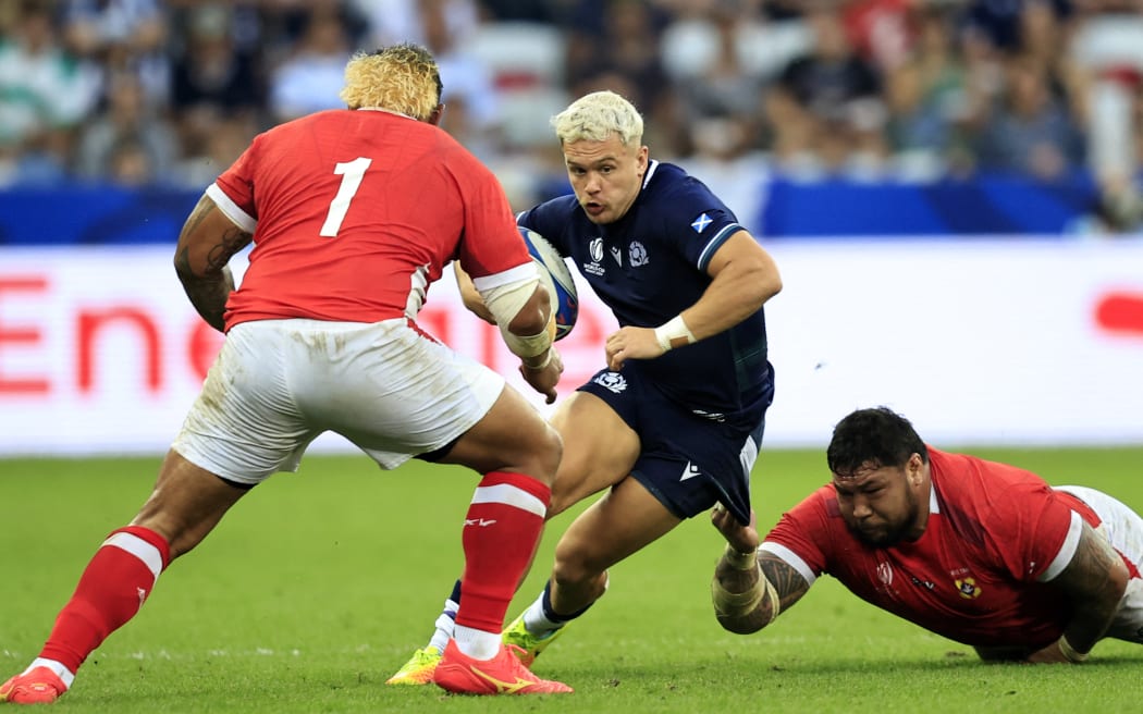 Scotland's wing Darcy Graham (C) is tackled by Tonga's tighthead prop Ben Tameifuna (R)  during the France 2023 Rugby World Cup Pool B match between Scotland and Tonga at Stade de Nice in Nice, southern France on September 24, 2023. (Photo by Valery HACHE / AFP)