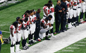 Atlanta Falcons' Grady Jarrett and  Dontari Poe kneel during the playing of the national anthem prior to the start of the game between the Atlanta Falcons and the Detroit Lions on September 24, 2017 at Ford Field in Detroit, Michigan.