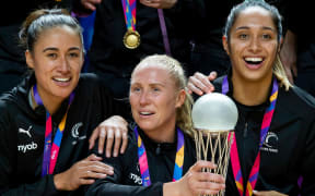 New Zealand captain Laura Langman holds the Netball World Cup trophy along with Maria Folau and Phoenix Karaka.