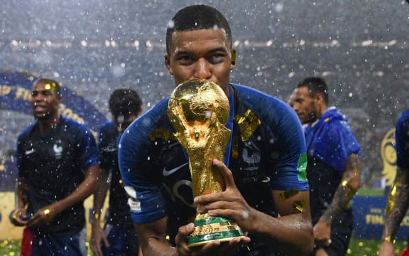 Kylian Mbappe kisses the World Cup trophy