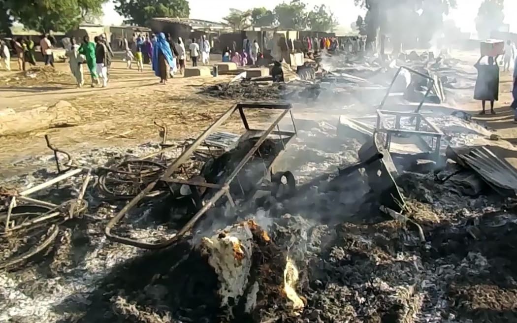 Smoldering ashes and charred items  in Budu near Maiduguri on July 28, 2019, after the latest attack by Boko Haram fighters on a funeral in northeast Nigeria has left 65 people dead.