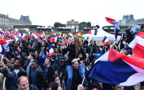 Supporters of the 'En Marche!' (Onwards!) political movement of Emmanuel Macron celebrate after the results announced at the Esplanade du Louvre in Paris.