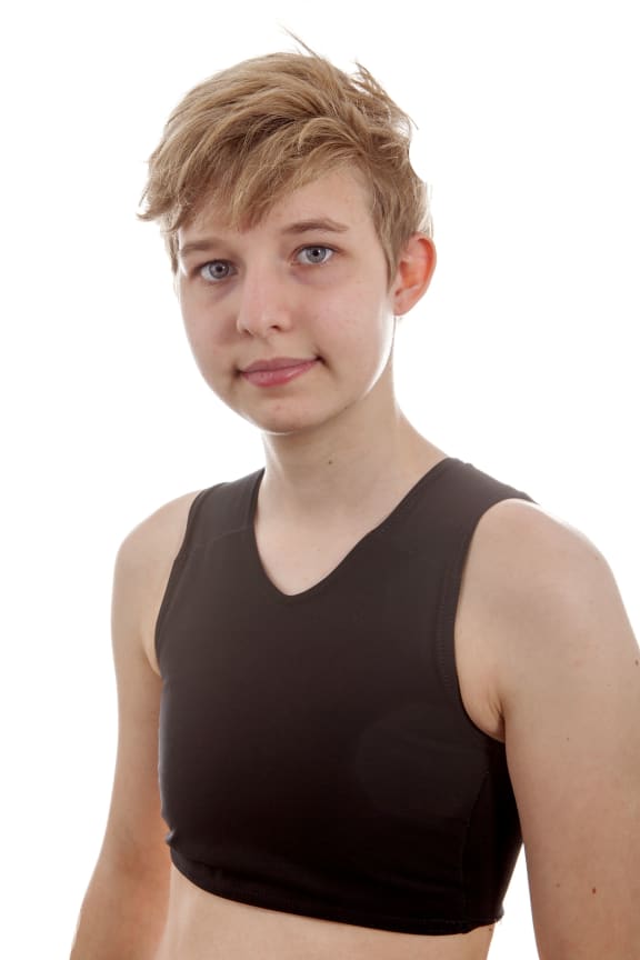 A photo of a teenage transgender boy wearing a binder