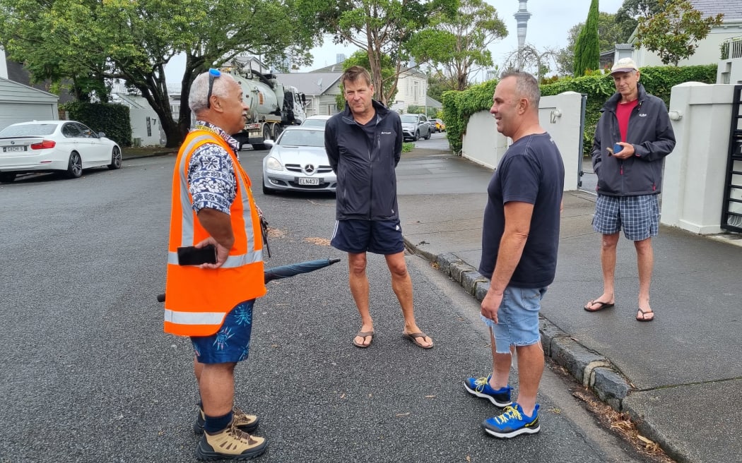 London Street residents quizzing a WaterCare services contractor about their stormwater issues, after flooding and landslips on the street following heavy rains and flooding across Auckland. 30 January, 2023