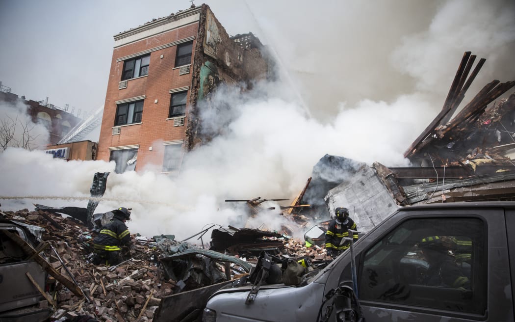 Smoke pours from the debris of a collapsed building in East Harlem.