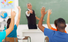 20235288 - group of students with hands up in classroom during a lesson