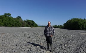 Ongaonga farmer Alistair Setter stands in the middle of the dry Waipawa River bed.