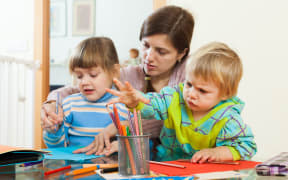 Mother and children sketching with pencils at home