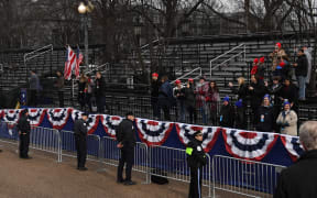 Supporters of US President Donald Trump and First Lady Melania Trump watch as they drive the inaugural parade route on Pennsylvania Avenue in Washington DC following swearing-in ceremonies on Capitol Hill.