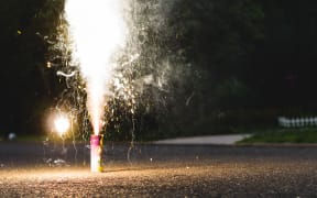 A small firework is set off on a street.