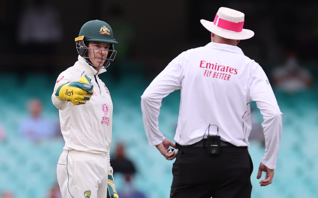 Australia's captain Tim Paine (L) speaks with an umpire during the second day of the third cricket Test match between Australia and India at the Sydney Cricket Ground (SCG) in Sydney on January 8, 2021.