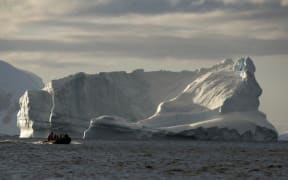 Tourists cruise alongside icebergs in the western Antarctic peninsula.