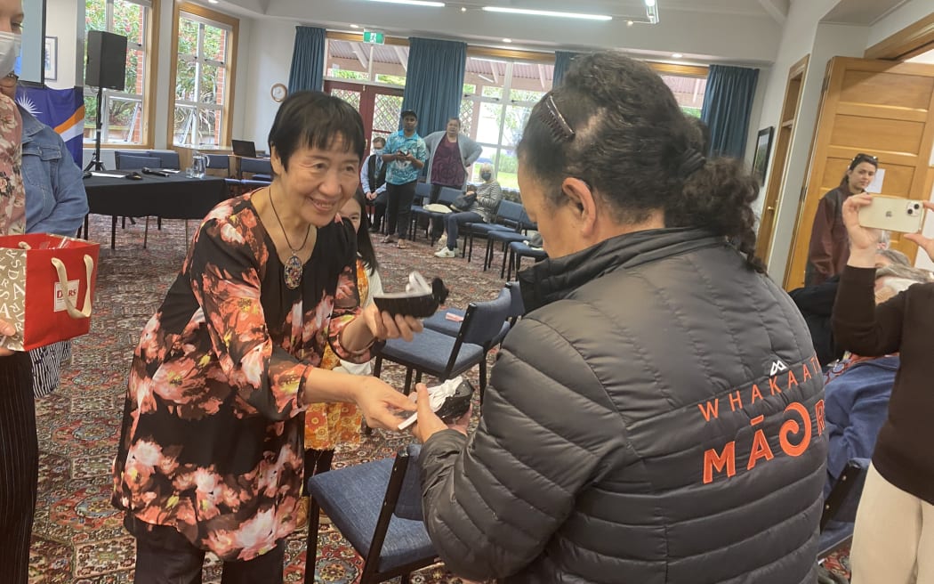 Toshiko Tanaka gives gift to Hilda Halkyard-Harawira at the 'Nuclear Connections Across Oceania' conference in Dunedin 2022.
