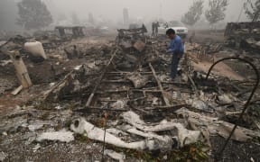 A man looks for items in the remains of his mobile home after a wildfire swept through the R.V. park destroying multiple homes in Estacada, Oregon