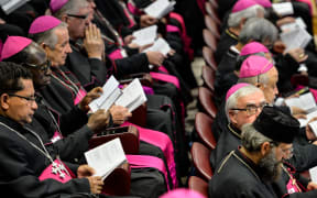 Bishops hold books as the Pope reads prayers at the morning session of the last day of the Synod on the Family at the Vatican.