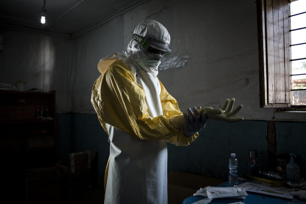 A health worker puts on protective equipment before entering the red zone of a MSF (Doctors Without Borders) supported Ebola Treatment Centre.