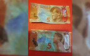 A real $5 note (top) and a fake $5 note given out at the Safety Warehouse promotion.