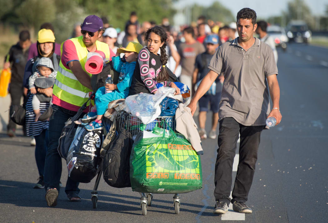 Hundreds of refugees from Syria, Iraq and Africa walk along the motorway towards the Austrian border.