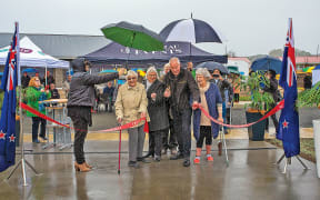 Kawerau Mayor Malcolm Campbell (centre) cuts the ribbon on the completed units alongside new owners (from left) Kath Cook, Averil Edhouse and Zita King.