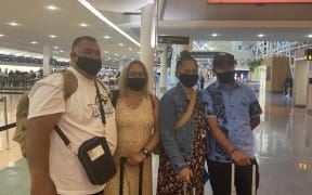 A family at Auckland airport awaits the first flight to the Cook Islands as part of the travel bubble