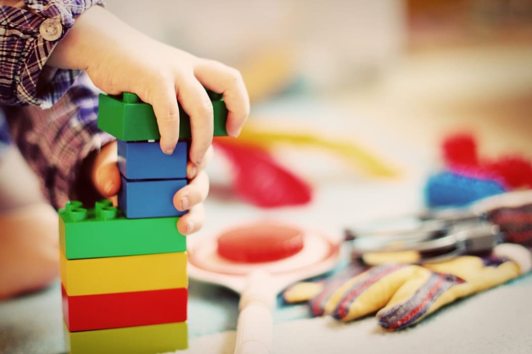 Kid playing with coloured blocks