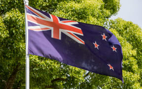 The current New Zealand flag flies up a flag pole.