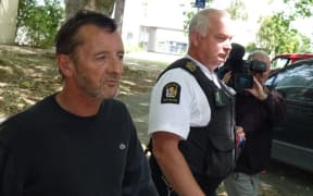 Phil Rudd leaves the court after breaching his bail conditions by being in the same shop as a witness.