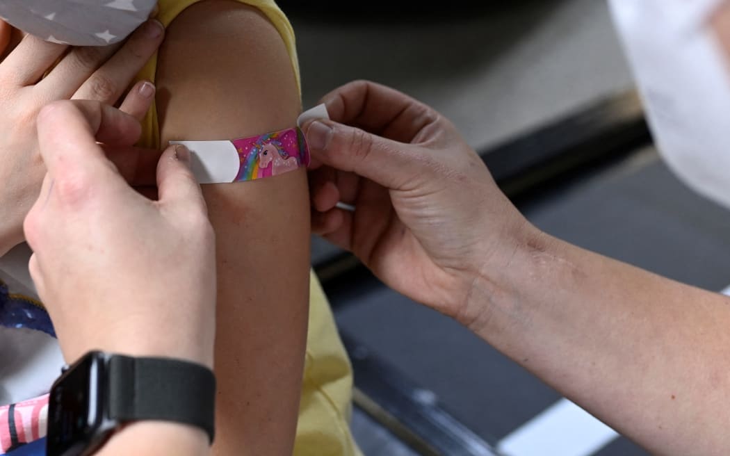 Six-year-old Hannah (L) receives a plaster after being vaccinated with the Pfizer BioNTech vaccine for children at a vaccination center at a car dealership in Iserlohn, western Germany, on January 5, 2022. I did.