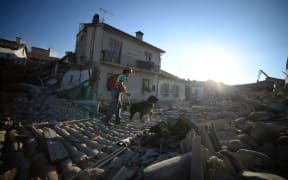 A rescue worker and dog searching for trapped people in  Amatrice.