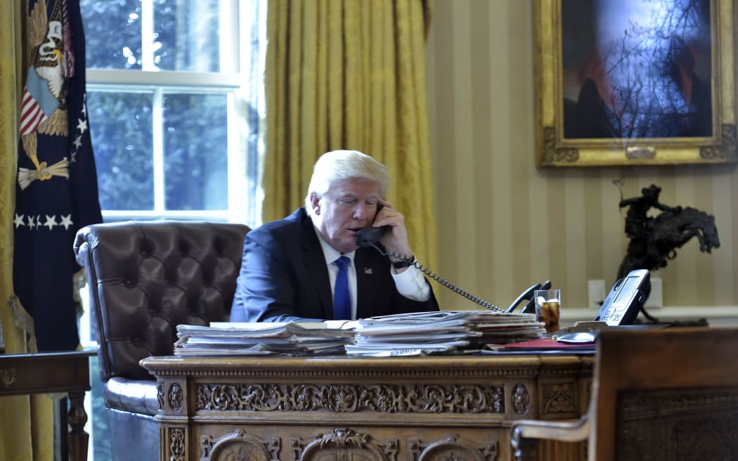 Donald Trump on the telephone in the Oval Office of the White House.
