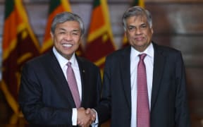 Sri Lanka’s Prime Minister Ranil Wickremesinghe (R) shakes hands with Malaysian Deputy Prime Minister Ahmed Zahid Hamidi.