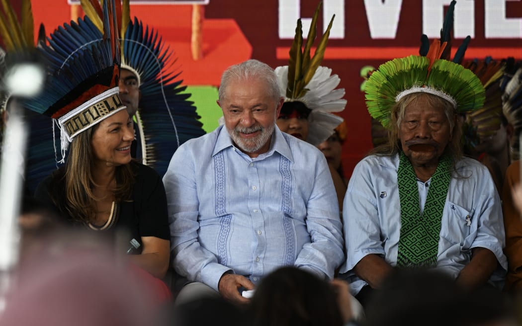 Brazilian President Luiz Inacio Lula da Silva (centre), sits with his wife (left) and indigenous leader of the Kayapo tribe Cacique Raoni Metuktire (right) at the Terra Livre Indigenous summit discussing land rights and indigenous culture, on 28 April, 2023.