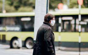 A pedestrian wearing a mask during level 2, Wellington 15 February 2021