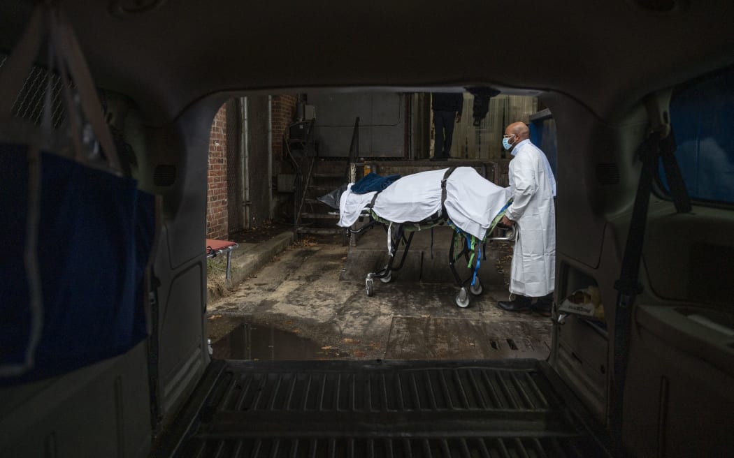 In this file photo taken on December 24, 2020 Maryland Cremation Services transporter Reggie Elliott brings the remains of a Covid-19 victim to his van from the hospital's morgue in Baltimore, Maryland during the Covid-19 pandemic.