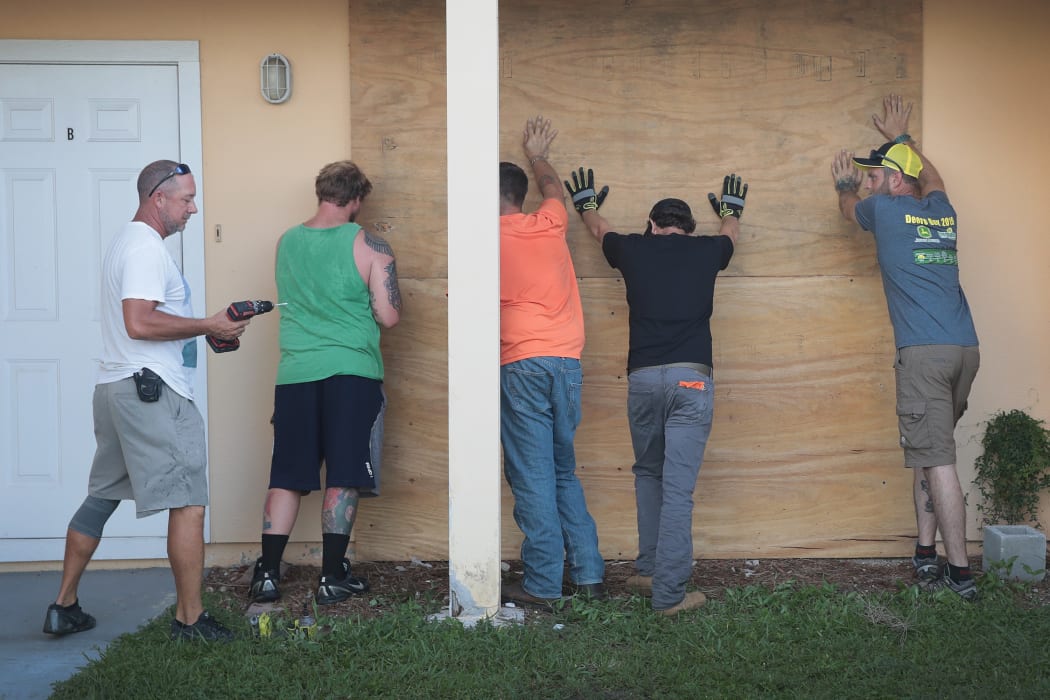 Workers help a friend board up his apartment building in Fort Pierce, Florida.