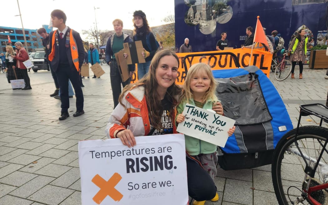 一位母亲和孩子在 2023 年 5 月 26 日的气候罢工中举着标语牌
