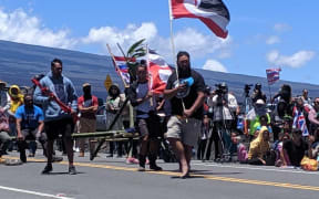 Mahara Nicholas waving the tino rangatiratanga flag at Mauna Kea.