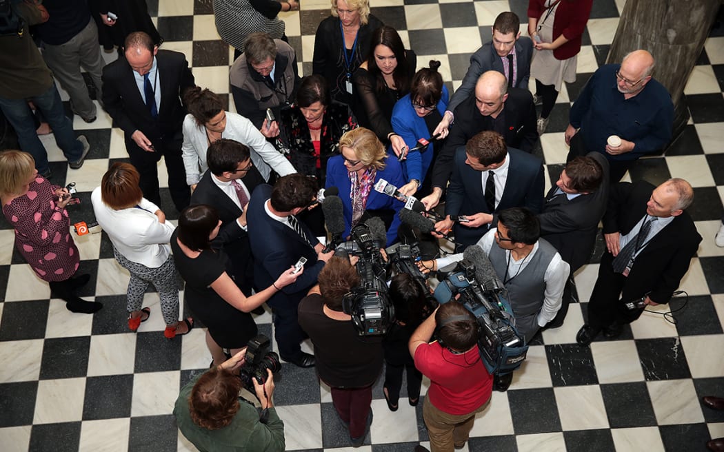 Media surround Judith Collins before she enters the debating chamber..