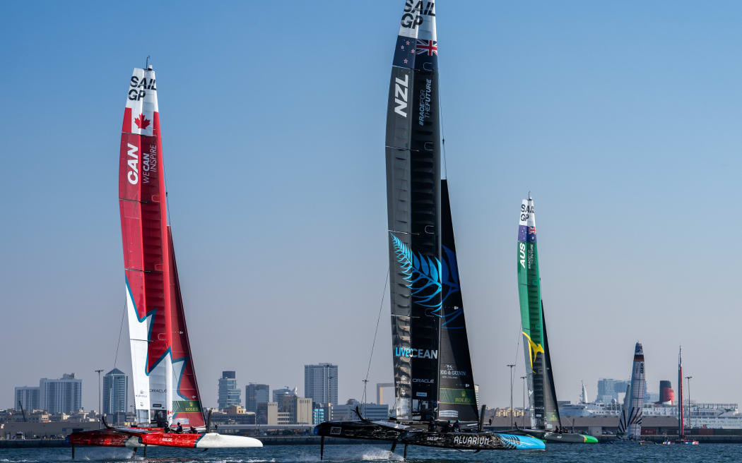 New Zealand SailGP Team helmed by Peter Burling, Australia SailGP Team helmed by interim driver Jimmy Spithill and ROCKWOOL Denmark SailGP Team helmed by Nicolai Sehested in action on Race Day 2 of the Emirates Sail Grand Prix presented by P&O Marinas in Dubai, United Arab Emirates. 10th December 2023. Photo: Bob Martin for SailGP. Handout image supplied by SailGP