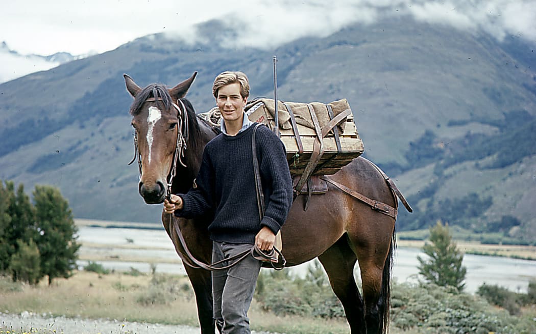Young hunter with horse in front of mountains