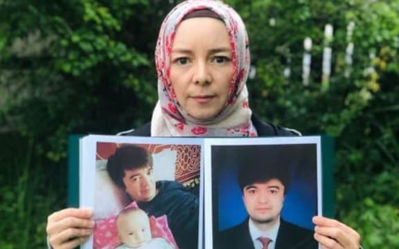 Rizwangul NurMuhammed holding photos of her brother, Maiwulana- detained in Xinjiang for the past four years.