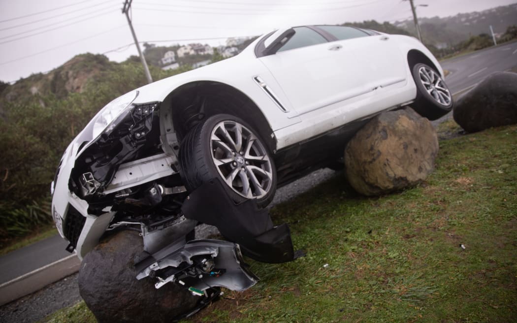A car has been pushed on top of boulder due to an intense storm along Wellington's South Coast