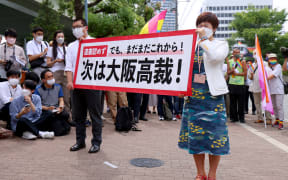Supporters for plaintiff, same-sex couples hold a banner "next, to the High Court" at the Osaka District Court in Osaka Prefecture on June 20, 2022. The court ruled that the ban on same-sex marriage was not unconstitutional.
