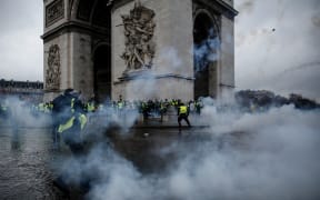 Demonstrators clash with riot police at the Arc de Triomphe during a protest of Yellow vests (Gilets jaunes) against rising oil prices and living costs.