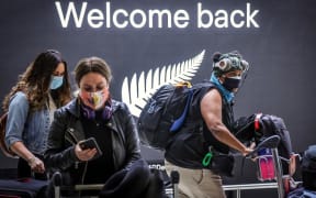 Passengers wearing face masks arrive from New Zealand at Sydney International Airport after Australia's border rules were relaxed under a new one-way trans-Tasman travel agreement that allow travelers from New Zealand to visit New South Wales without having to quarantine.