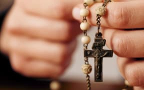hands holding rosary beads